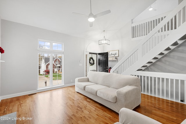 living room with ceiling fan, high vaulted ceiling, and wood-type flooring