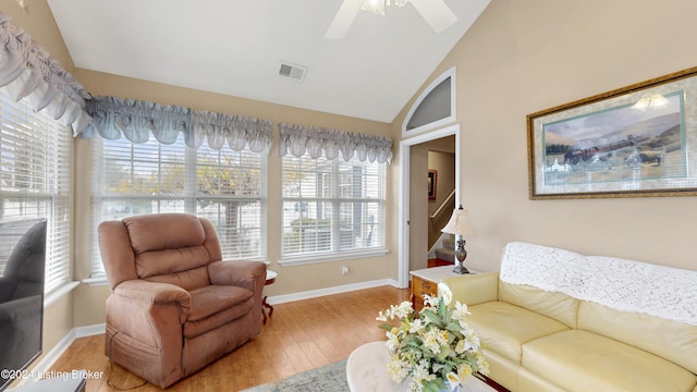 living room featuring plenty of natural light, wood-type flooring, and vaulted ceiling