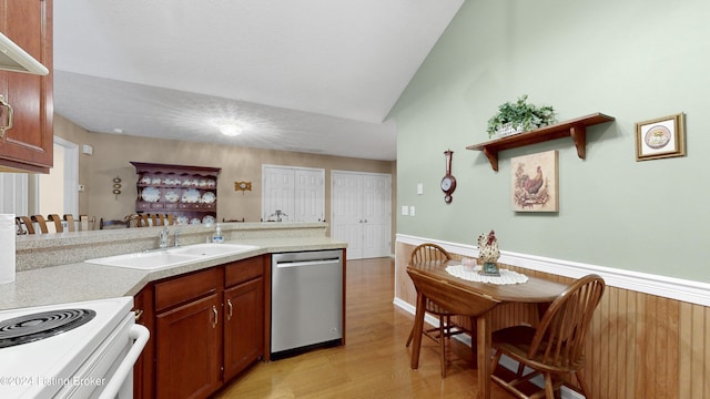 kitchen featuring vaulted ceiling, light hardwood / wood-style floors, stainless steel dishwasher, and sink