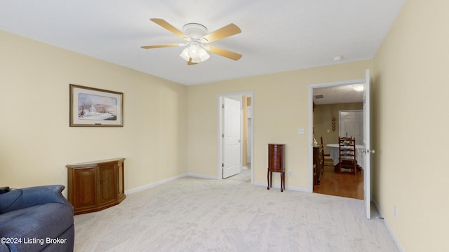 sitting room featuring ceiling fan and light colored carpet