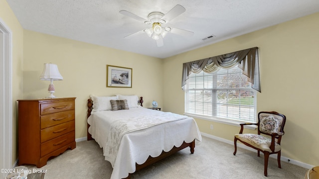 bedroom with light carpet, a textured ceiling, and ceiling fan