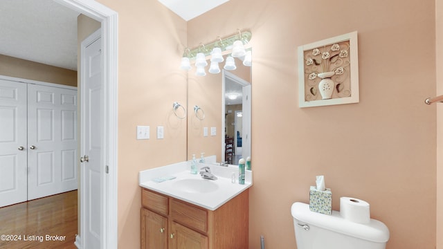 bathroom with hardwood / wood-style flooring, vanity, and toilet