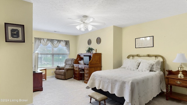 carpeted bedroom with ceiling fan and a textured ceiling