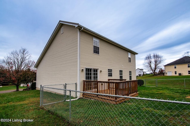 rear view of property featuring a yard and a deck