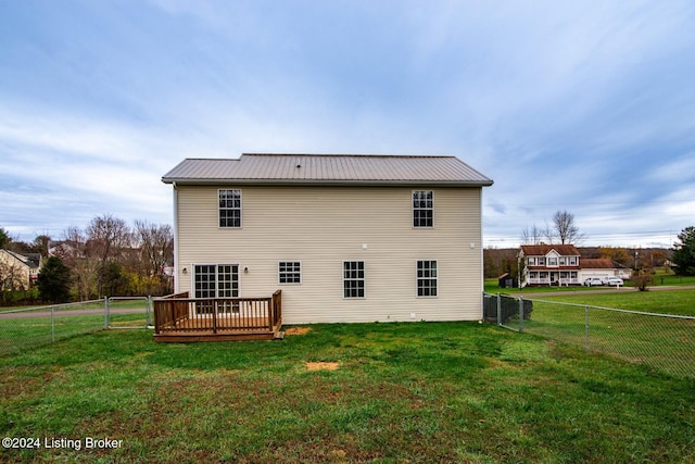 rear view of property featuring a deck and a yard