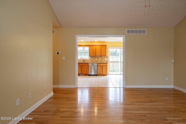 unfurnished living room with sink and light hardwood / wood-style floors