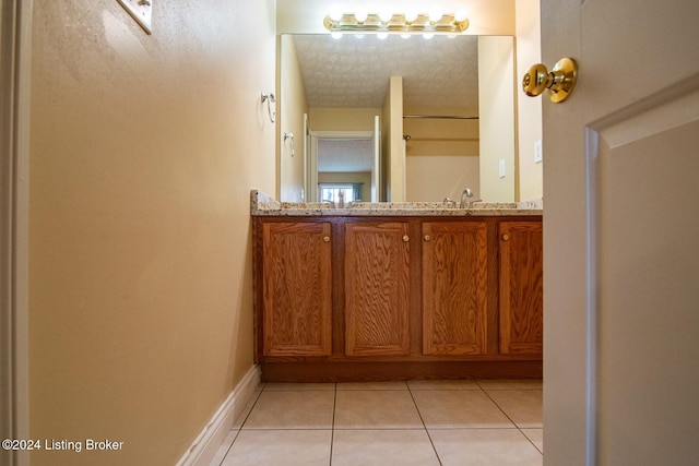 bathroom featuring tile patterned flooring, a textured ceiling, and vanity