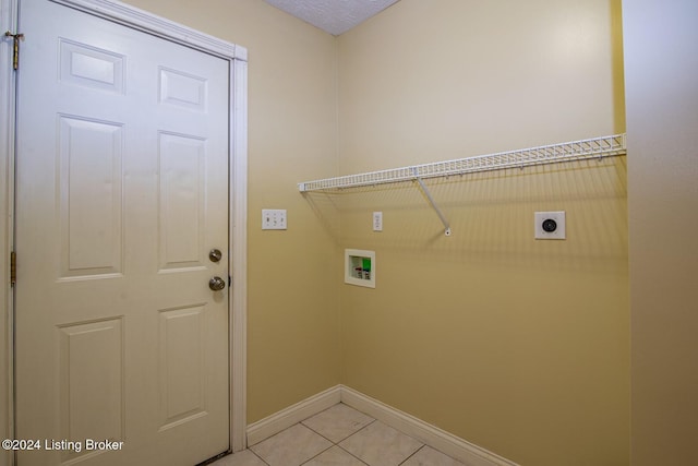 clothes washing area featuring electric dryer hookup, light tile patterned floors, and washer hookup