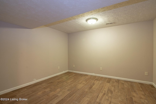 empty room featuring hardwood / wood-style flooring and a textured ceiling