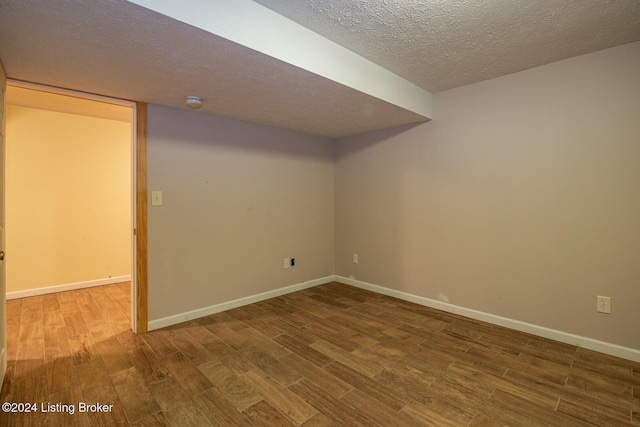 basement featuring wood-type flooring and a textured ceiling