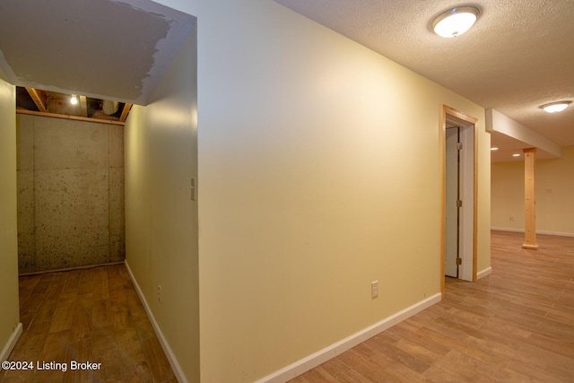 hallway featuring a textured ceiling and light wood-type flooring