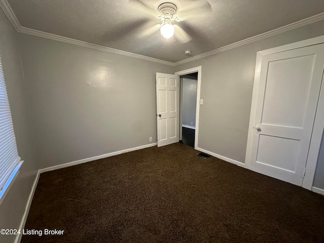 unfurnished bedroom featuring dark colored carpet, ceiling fan, ornamental molding, and a textured ceiling