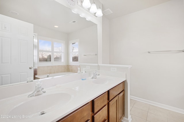 bathroom featuring tile patterned flooring, a bath, and vanity