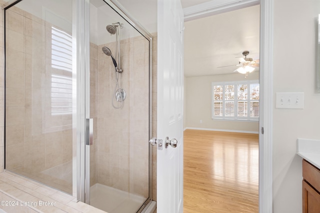 bathroom featuring vanity, ceiling fan, a shower with shower door, and wood-type flooring