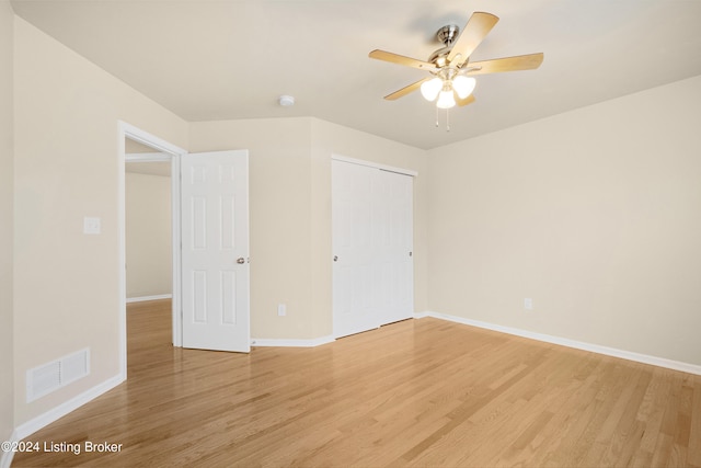 unfurnished bedroom with ceiling fan, a closet, and light hardwood / wood-style flooring