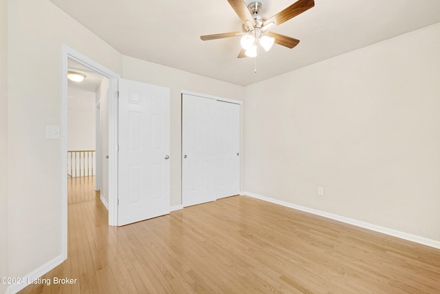 unfurnished bedroom featuring light hardwood / wood-style floors, a closet, and ceiling fan