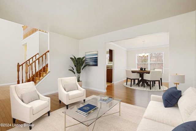 living room with a chandelier, crown molding, and light hardwood / wood-style floors