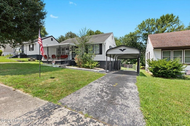 bungalow-style house with covered porch, a front yard, and a carport