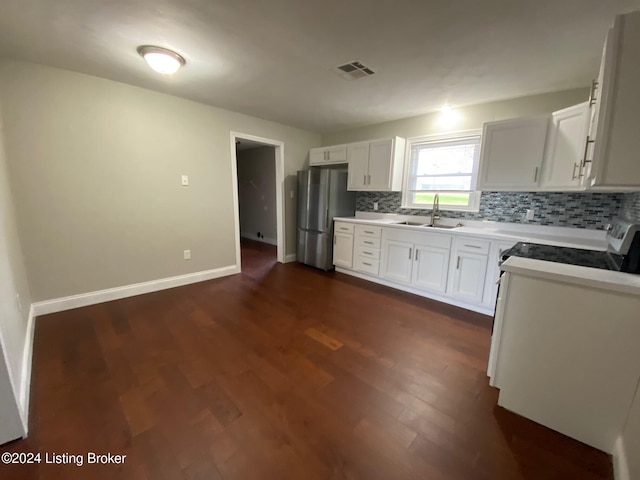 kitchen with stainless steel fridge, stove, dark wood-type flooring, sink, and white cabinetry