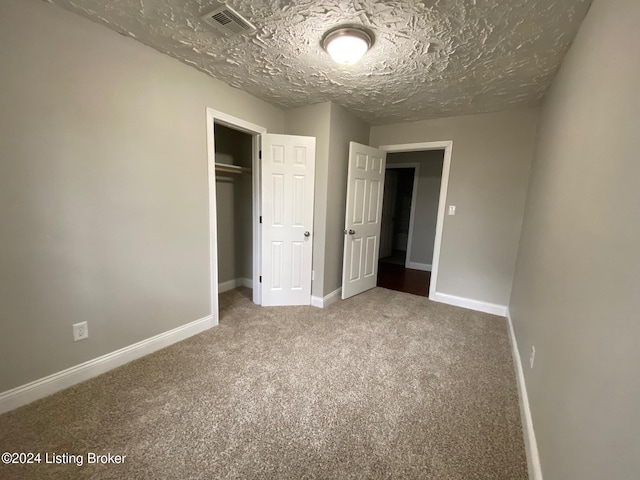 unfurnished bedroom featuring carpet flooring, a closet, and a textured ceiling