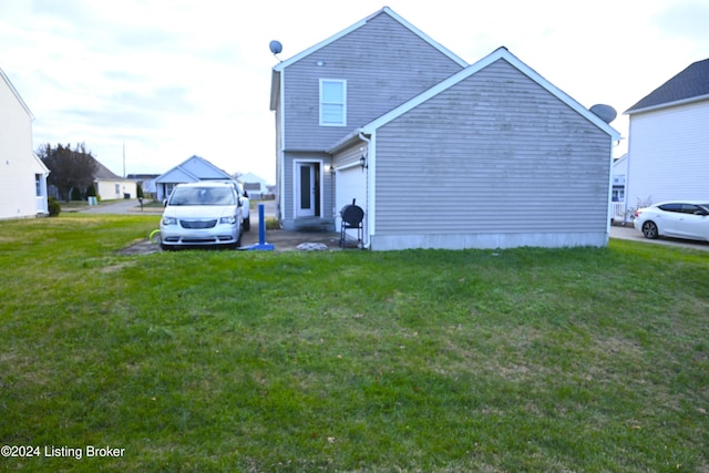 rear view of property with a lawn and a garage