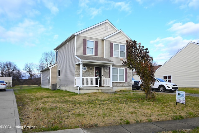 view of front of home with a front lawn and central AC