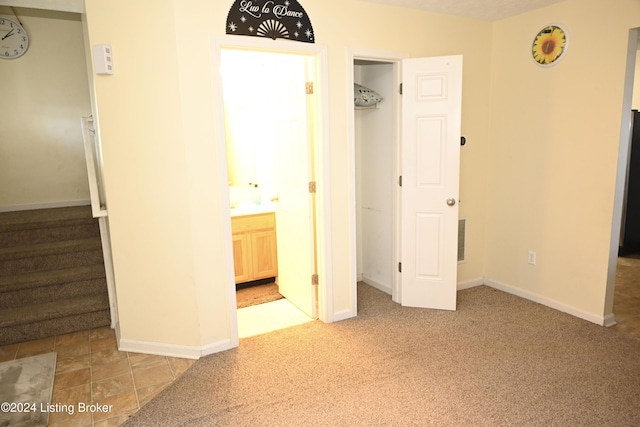 unfurnished bedroom with carpet floors and ensuite bath