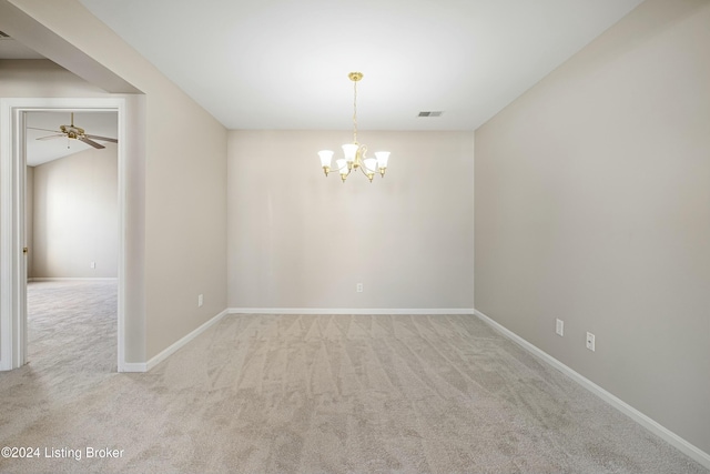 carpeted spare room featuring ceiling fan with notable chandelier