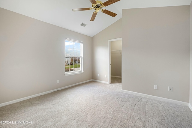 carpeted spare room with ceiling fan and high vaulted ceiling