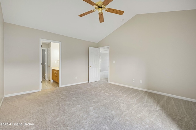 unfurnished bedroom featuring connected bathroom, ceiling fan, high vaulted ceiling, and light carpet