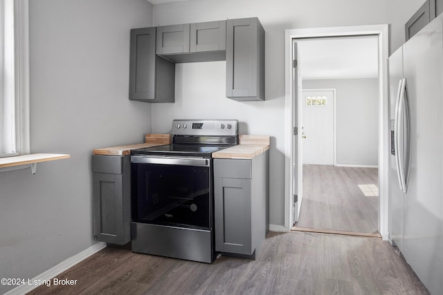 kitchen with gray cabinets, dark wood-type flooring, and appliances with stainless steel finishes