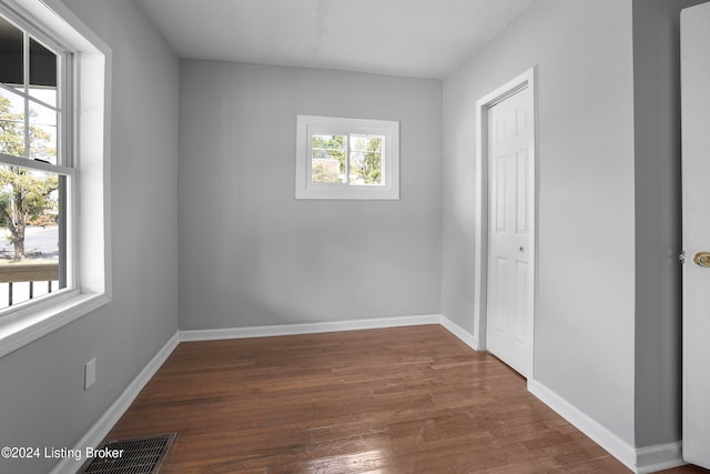 unfurnished bedroom with dark hardwood / wood-style floors and multiple windows