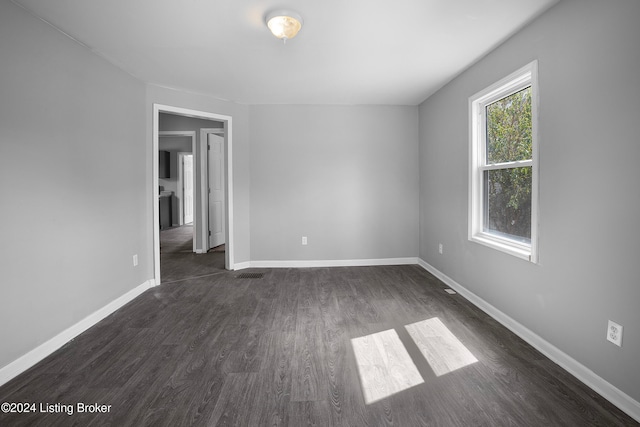 empty room with dark hardwood / wood-style flooring