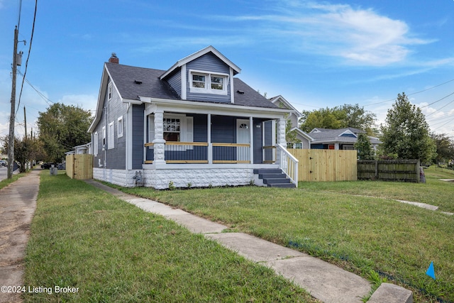 bungalow featuring covered porch and a front yard