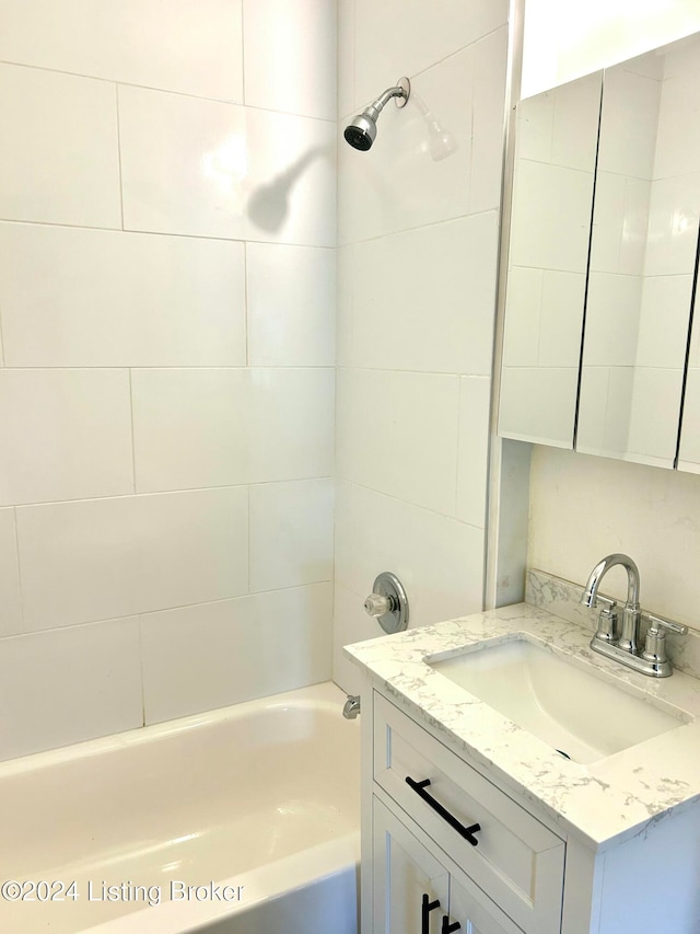 bathroom featuring vanity and tiled shower / bath