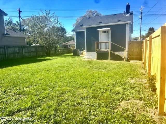 back of house with cooling unit and a lawn