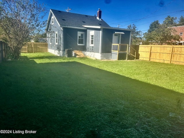 back of house with a lawn and central AC