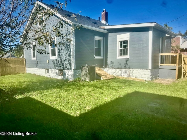 rear view of house featuring a yard