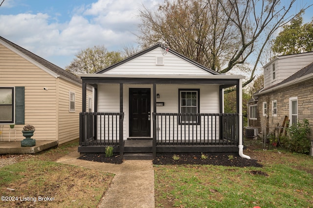 bungalow with covered porch and a front lawn