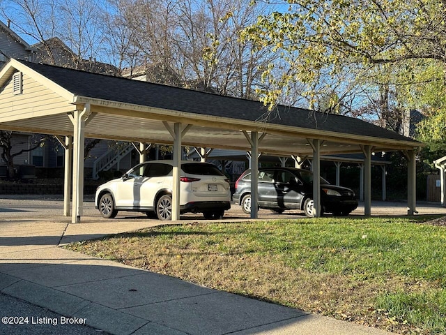 view of parking featuring a yard and a carport