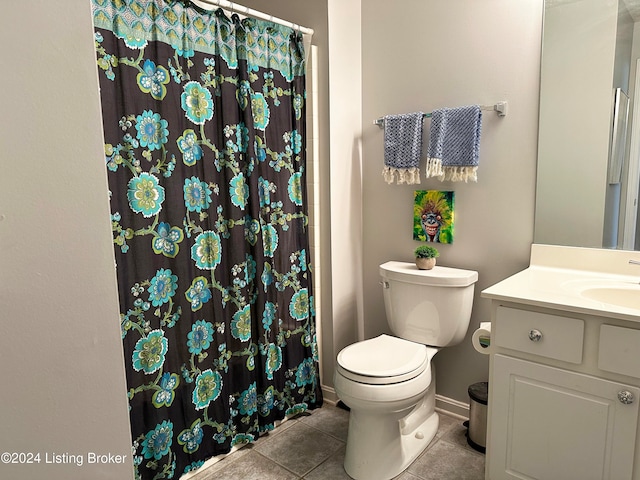 bathroom featuring toilet, vanity, tile patterned floors, and curtained shower