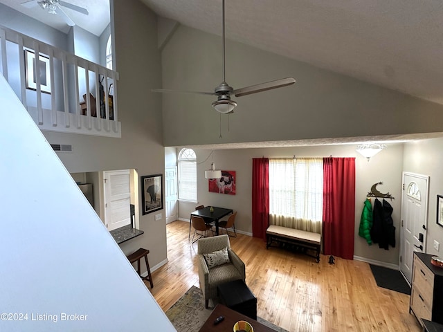 bedroom featuring ceiling fan, light hardwood / wood-style floors, and high vaulted ceiling