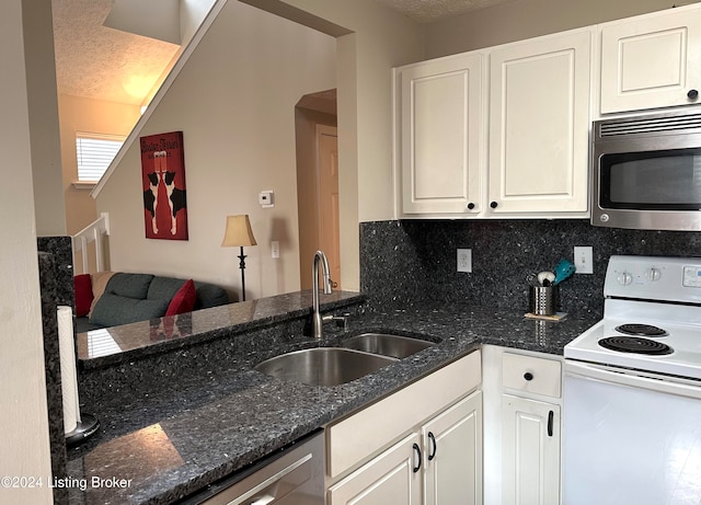 kitchen with dark stone counters, a textured ceiling, sink, electric stove, and white cabinets