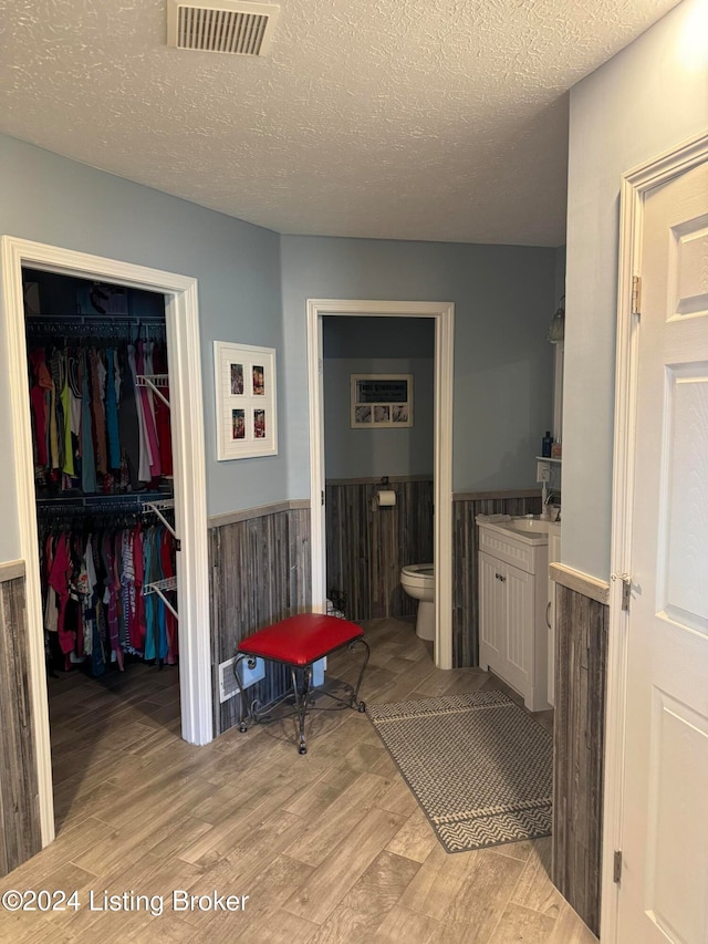 bathroom featuring hardwood / wood-style floors, a textured ceiling, toilet, and sink