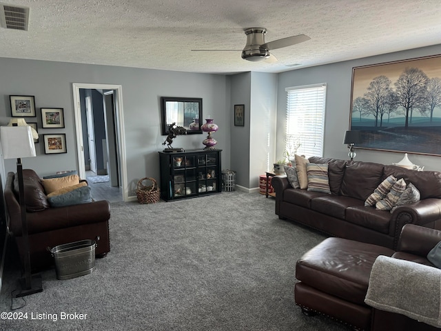 living room with a textured ceiling, carpet floors, and ceiling fan