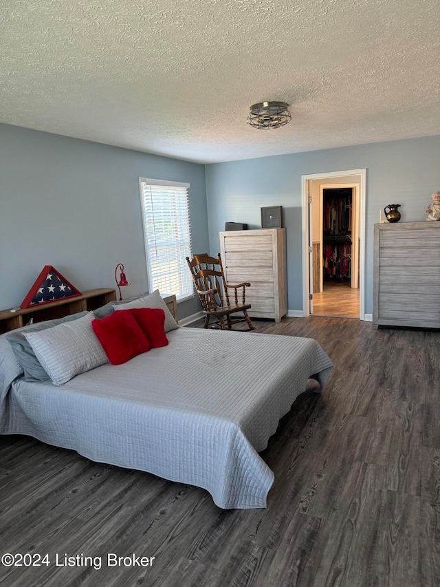 bedroom featuring a textured ceiling and dark hardwood / wood-style floors