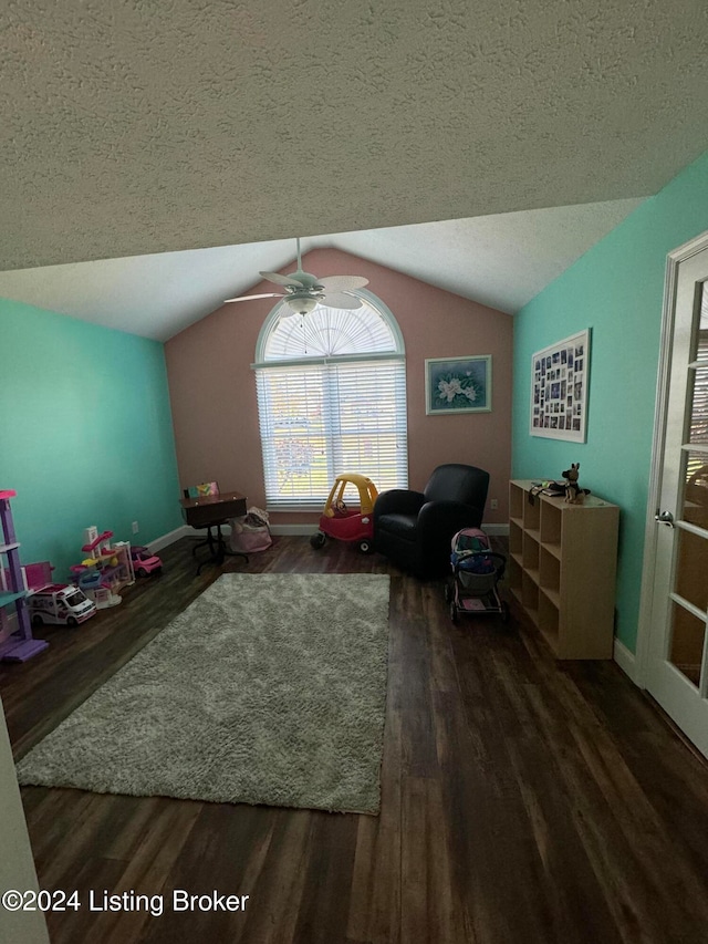 living area featuring a textured ceiling, dark hardwood / wood-style floors, vaulted ceiling, and ceiling fan