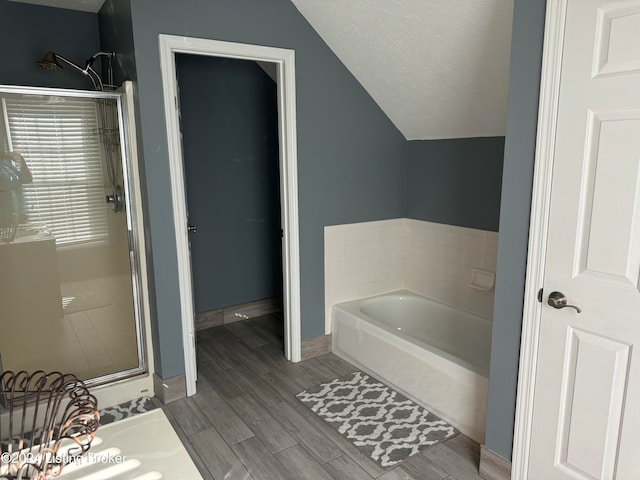 bathroom featuring hardwood / wood-style flooring, a textured ceiling, plus walk in shower, and vaulted ceiling