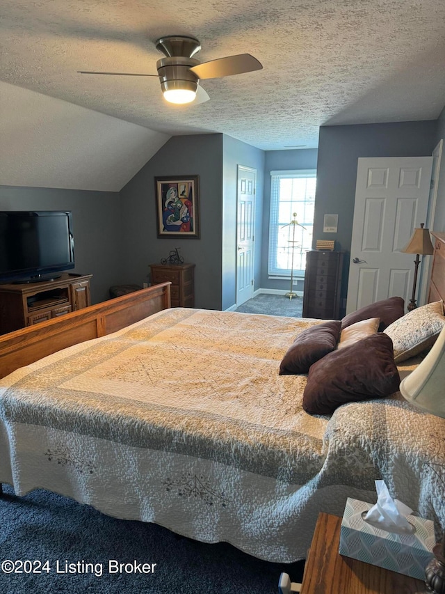 bedroom with a textured ceiling, vaulted ceiling, and ceiling fan