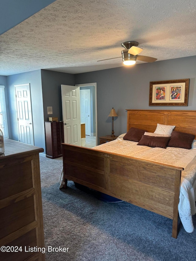 bedroom featuring dark colored carpet, ceiling fan, and a textured ceiling